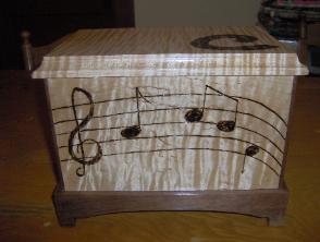 Box for my daughter.  Curly Maple with walnut base.  Musical motif hand burnt in.
